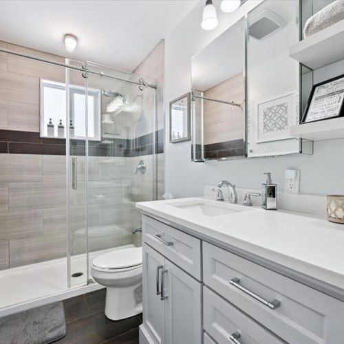 Modern bathroom with in-floor heating, walk-in glass shower, and clean, contemporary fixtures.