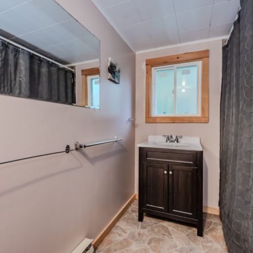 A simple and functional bathroom setup, complete with a vanity and a shower curtain for privacy.