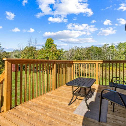 A sunny outdoor sitting area overlooking the lawn and surrounding Bruce Peninsula countryside.