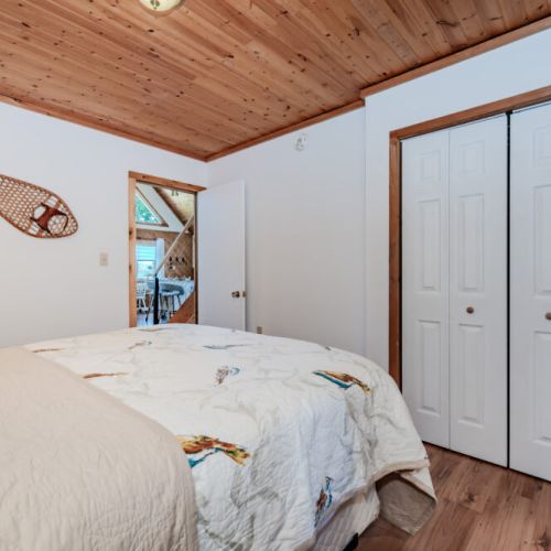 Charming bedroom with rustic decor and plenty of closet space — a cozy home base for your next lakeside family vacation.