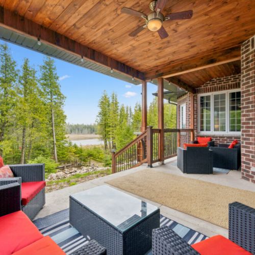 Covered patio with comfortable outdoor seating and tranquil views of the water