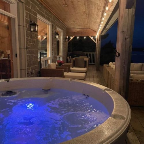 As night falls, relax in the glow of the hot tub with the tranquil sounds of the water just steps away, perfect for unwinding after a day of adventure.