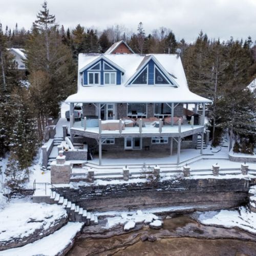 Charming lakefront vacation rental with expansive deck, perfect for family getaways, winter retreats, and scenic waterfront escapes.