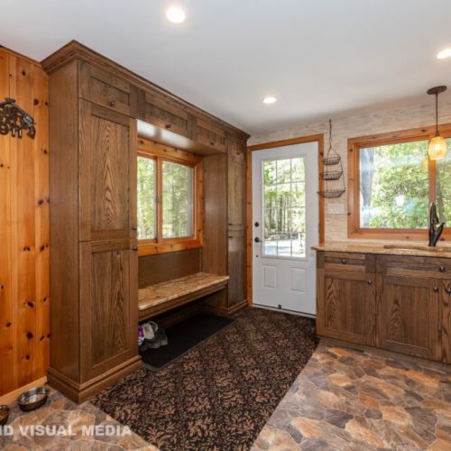 Inviting entryway with custom wood cabinetry and storage—warm cottage charm throughout.