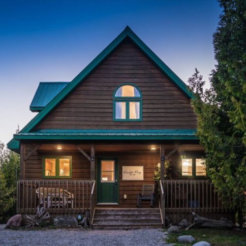 Welcome to Paradise Pines, a custom-built waterfront getaway with warm wood finishes and a bright open-concept design.