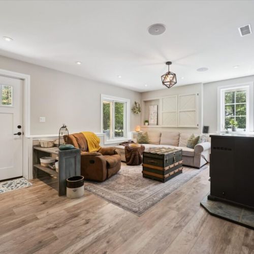 Cozy lounge space featuring a wood stove and open layout connecting the main living areas.