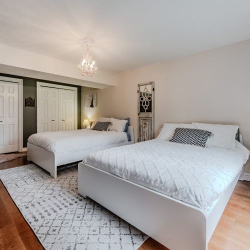 Light-filled bedroom with crisp white linens, hardwood floors, and a serene vibe—perfect for a restful, clutter-free sleep.