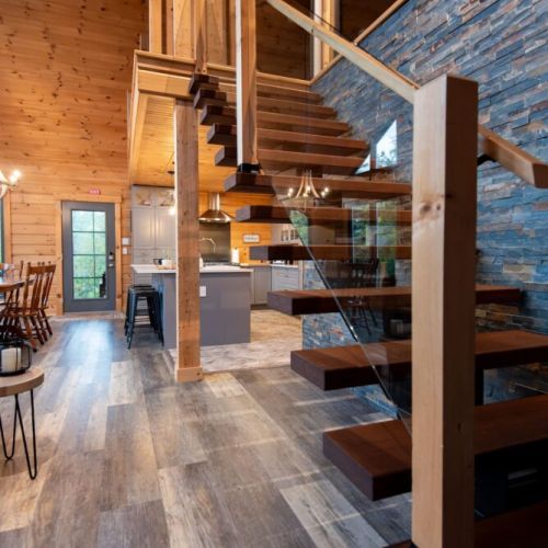 Architectural charm—beautiful floating stairs and a striking stone wall create a modern rustic feel.