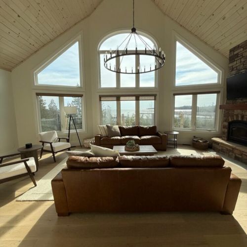 Relax in a spacious great room with soaring ceilings and panoramic lake views—your perfect cozy escape after a day of adventure.