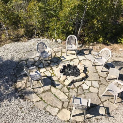 Gather around the rustic stone fire pit for unforgettable nights under the stars — ideal for cozy cottage evenings.