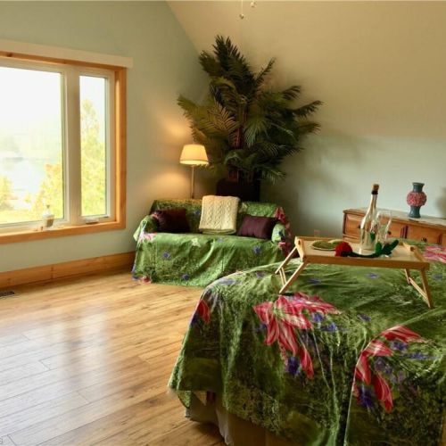 Relax in the cozy upstairs loft sitting area, a peaceful spot to read or unwind with views of the trees.