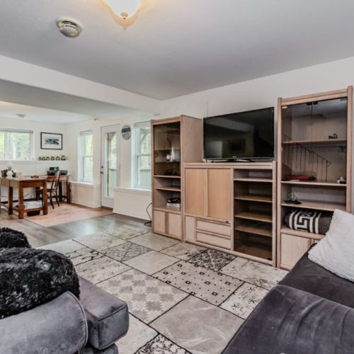 The inviting living area is perfect for gathering with family and friends, featuring comfortable seating, a flat-screen TV, and plenty of natural light.