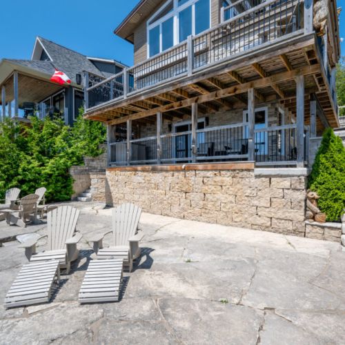 Full view of the cottage from the shoreline—multi-level decks designed for outdoor living.