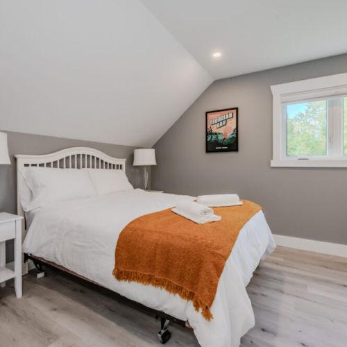 Guests will feel right at home in this beautifully appointed bedroom, featuring fresh linens, a cozy bed, and tasteful decor to create a calming atmosphere.