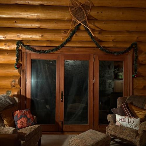 Snowy night lounge, settle in by the doors with twinkly garland and that classic cabin calm