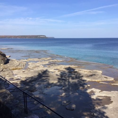 Natural stone ledges meet clear, blue water.