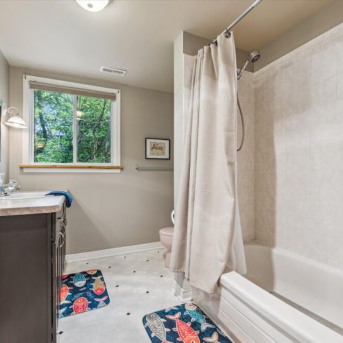 Bright and functional with playful touches like fish-themed rugs and natural views through the window — a great spot to refresh after a beach day.