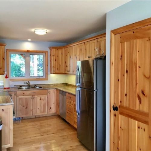 Enjoy a fully equipped kitchen with warm wood cabinetry and modern stainless steel appliances for easy cottage meals.