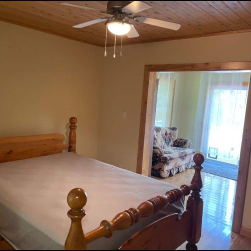 Spacious bedroom with warm wood finishes and walk-through lounge—ideal for couples or solo travelers looking for comfort and charm.