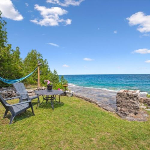 Chairs and table just steps from the rocky shore.