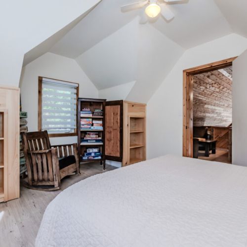 Bright and cozy bedroom featuring a reading nook and a library of board games — perfect for a relaxing cottage vacation near the lake!