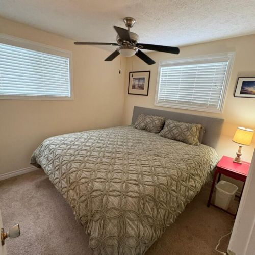 Comfortable bedroom with a cozy bed and ceiling fan for a great night’s sleep.