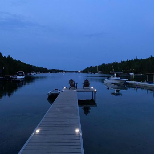 Relax under the soft glow of dock lights as night gently falls over the bay. Enjoy the stillness of the water, perfect for a quiet moment or stargazing in the comfort of Adirondack chairs.