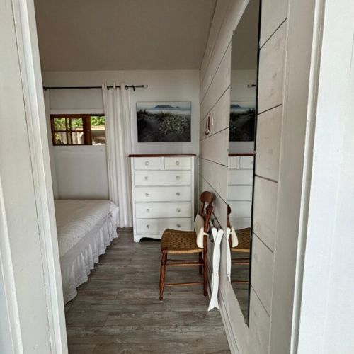 Glimpse into the airy primary bedroom from the hallway.