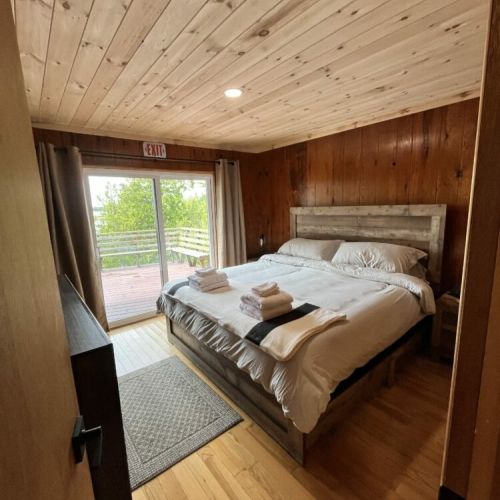 The spacious master bedroom featuring a king sized bed and a private balcony with stunning views, combining comfort with beautiful vistas.
