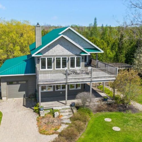 Stunning exterior view featuring large wraparound decks and peaceful privacy.