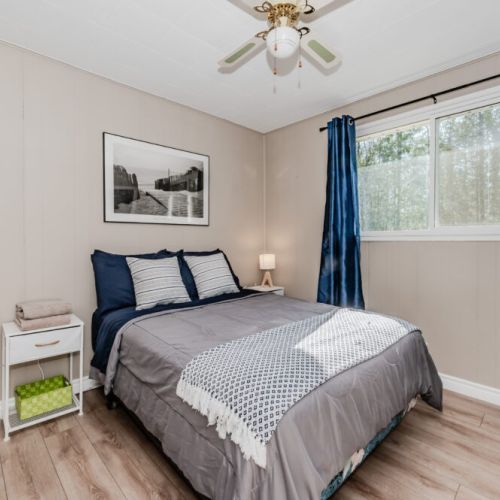Cozy bedroom retreat with queen bed, soft linens, and peaceful woodland views—perfect for restful nights during your countryside escape.
