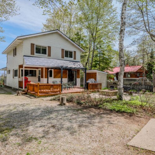 The backyard opens up to serene lake views, enhancing the cottage's tranquil ambiance.
