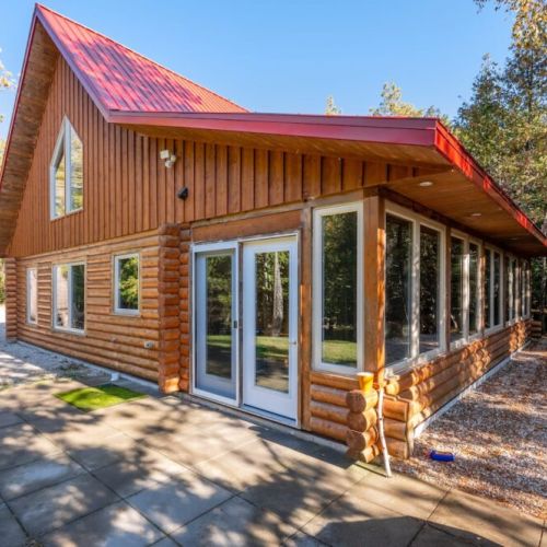 A view of the Peninsula room with a view of the back 40 acres, bathed in natural light, providing a special space to enjoy the surrounding forest, with floor-to-ceiling windows bringing the outdoors in.