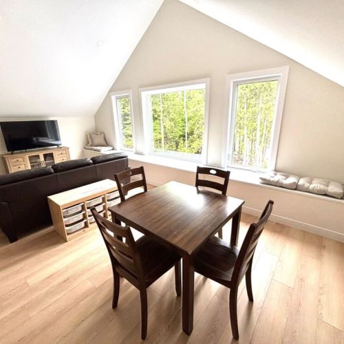 A versatile family zone – this spacious upper-level living and dining area includes board games, extra TV space, and a cozy place for group meals or rainy-day fun.