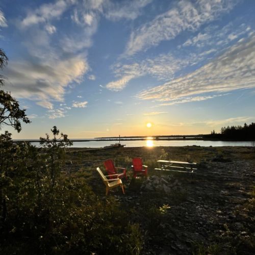 Gather around the cozy fire pit with vibrant Adirondack chairs, set against the backdrop of stunning waterfront views—an ideal spot for evening relaxation and marshmallow toasting.