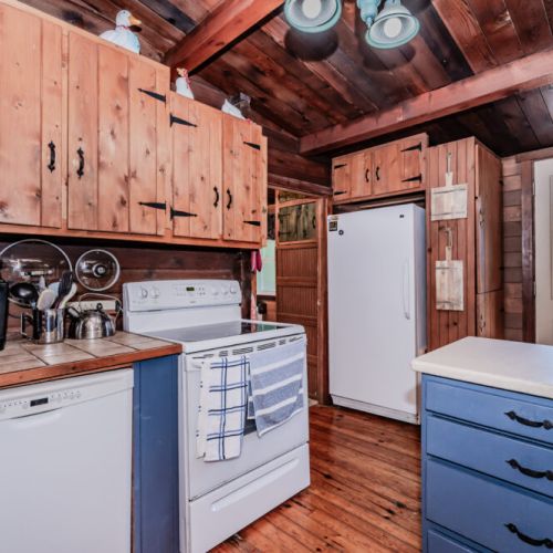 Delight in cooking at this cozy log cabin vacation rental, featuring a full kitchen with rustic wood cabinets, modern appliances, and scenic views—ideal for weekend escapes, romantic retreats, and family-friendly vacations in nature.