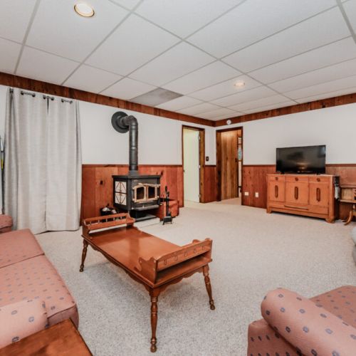 Spacious lower-level living area with TV and fireplace, ideal for cozy evenings at your lakeside vacation rental.