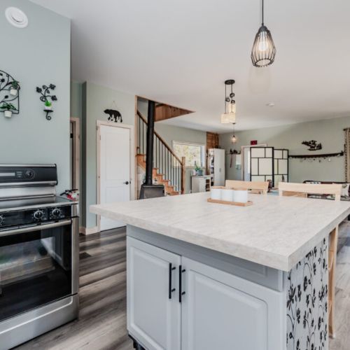 Enjoy open-concept living with a spacious kitchen island, modern amenities, and a welcoming cottage atmosphere perfect for gatherings.