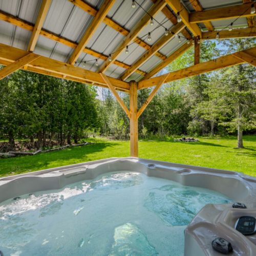 Embrace the serenity of Starry Haven from the patio, featuring a rejuvenating hot tub under a rustic wooden gazebo—perfect for relaxing under the stars.