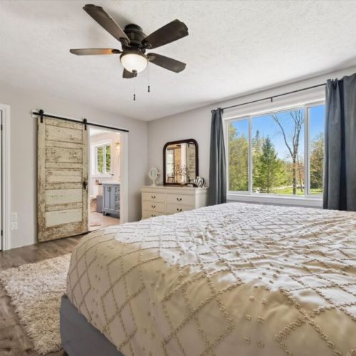 Bedroom 1: Relax in the spacious primary bedroom, complete with large windows overlooking the surrounding property.