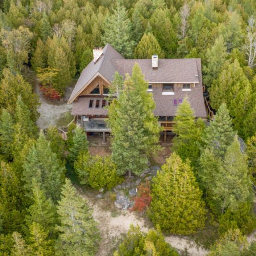 Timber Shores is beautifully nestled within a lush forest, offering unmatched privacy and tranquility. This aerial view highlights the cabin’s harmonious connection to its stunning natural surroundings.