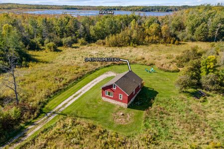 Smith Homestead sits surrounded by nature, with beautiful Ira Lake visible beyond the nearby forest.