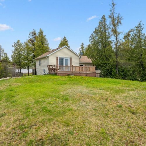 Surrounded by mature trees, the backyard offers privacy and room for guests to enjoy the outdoors.