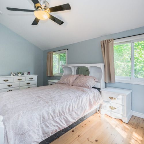 Enjoy the natural light streaming into this well-appointed bedroom, featuring a comfortable bed and ample storage.