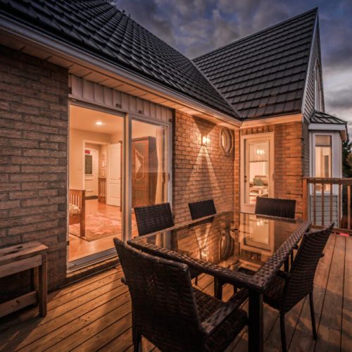As the sun sets, the deck transforms into a serene space for evening relaxation, with a stunning backdrop of the water.