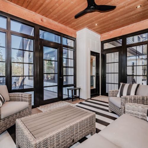 Unwind in the stylish screened-in porch with wicker lounge seating — a serene retreat for morning coffee or evening conversations.