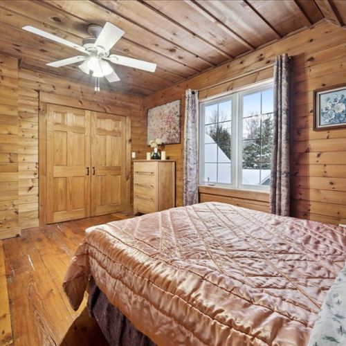 Another inviting upstairs bedroom with queen bed, lots of natural light, and classic cottage charm.