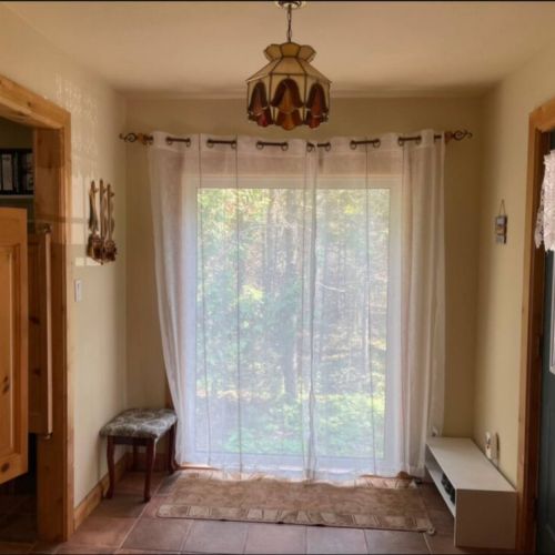 Welcoming entryway with a view to the woods. The perfect start to your peaceful escape in this cozy nature retreat.