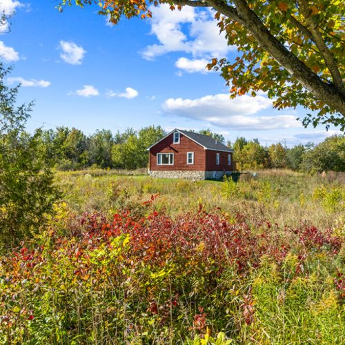 Historic Smith Homestead surrounded by colourful fields, mature trees and the peaceful beauty of the countryside.