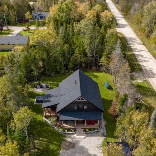 A peaceful and private location, this aerial shot captures the tranquility of the cottage surrounded by trees and nature.